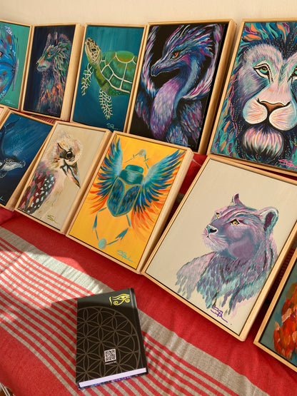 Display of all 13 canvases painted by Stacie Spiler, local Australian Artist, representing the unique themes for each month of the Infinite Journal by Ira Light. The image also features the back cover showcasing the Ira Light logo and the Flower of Life sacred geometry, highlighting the authenticity and spiritual significance of the journal's artwork